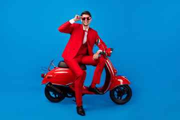 Full length photo of young handsome guy happy positive smile sit bike cool sunglass isolated over blue color background