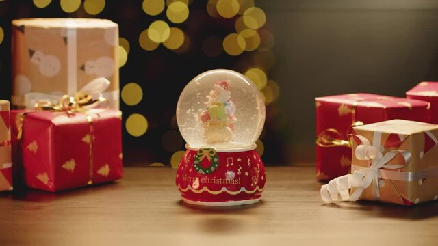 Christmas snowglobe and Christmas gifts on table