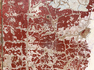 Old shabby concrete cracked white textured wall painted with red burgundy colour. Wallpaper, background. Horizontal. Selective focus