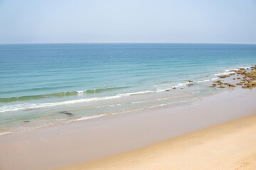 Fototapeta na wymiar Landscape of a beach with blond sand and rocks with cliffs in Cadiz, Spain