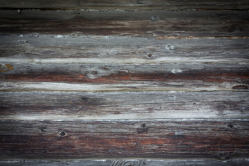 Wooden logs of an old house. Close-up. Weathered natural gray wood texture. Background. Horizontal photo