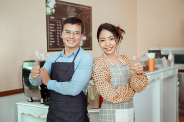 Portrait of cheerful baristas smiling in coffee shop