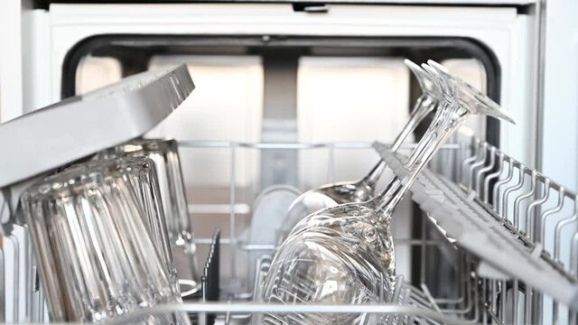 Housewife using dishwasher for cleaning glasses. House chores concept. 