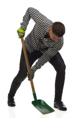 Man in lumberjack shirt is working with a shovel. Full length, isolated.