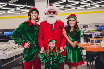 Photo of good mood funny santa claus assistants wear costumes smiling buying modern electronics...