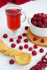 raspberry drink on a gray stone background, walls, glass cup with compote, fresh raspberries on a wooden table, cooling drink