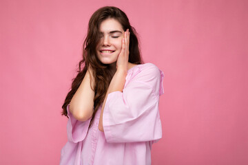 Photo of young positive happy smiling beautiful woman with sincere emotions wearing stylish clothes isolated over background with copy space and covering ears