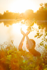 Woman  hands in prayer position and  heart shaped palms, blooming spring lush meadow with green...