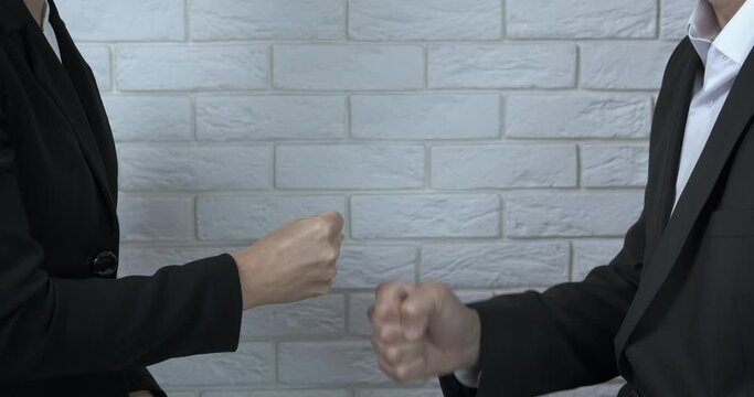 Rock paper scissors. A view of a bussines man and a woman play rock paper scissors in the office. A concept of taking decisions in different cases.