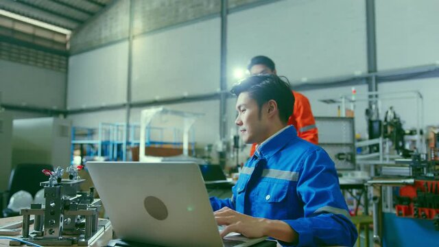 Co-working technician asian male engineer consult discussion laptop application result report discuss for quality control production line of cnc machine operate metal cutting work smart technology 