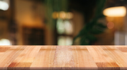 Empty wooden table top with lights bokeh on blur restaurant background.