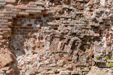 Arch in ancient brickwork on abandoned old house red brick wall fragment close-up