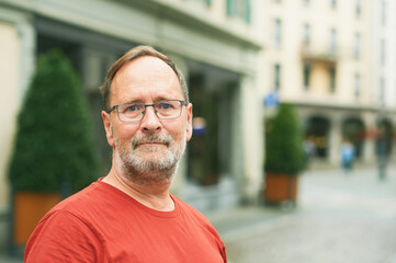 Outdoor portrait of middle age man on city street, wearing eyeglasses