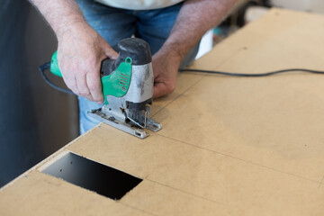 Cutting a hole with a jigsaw. DIY, professional work