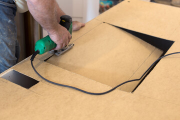 Cutting a hole with a jigsaw. DIY, professional work