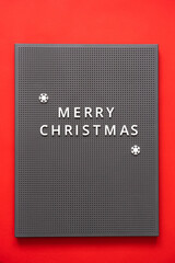 Merry christmas inscription on chalkboard. Red background. Blackboard with letters, New Years holiday.