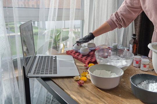 woman is taking an online lesson or watching a video on creating bath bombs. Online training, online classes. master creates handmade cosmetics