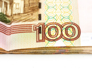 Money bills of the Russian Federation in denominations of one hundred rubles. Close-up on a white background.