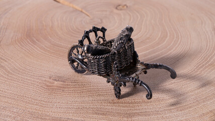 Beautiful old small silver cart on a wooden background.  Antique wagon with fishes in it. 