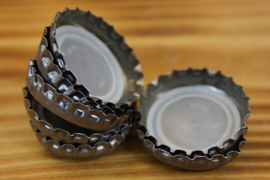 Bottle caps stacked on a flamed wooden board
