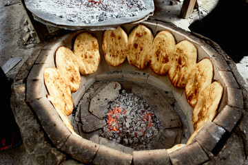 Bread in the tandoor. Traditional way of baking bread in the tandoor in Dagestan, Russia. - obrazy, fototapety, plakaty