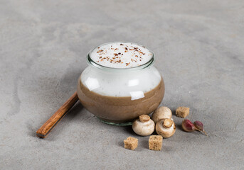 Mushroom cappuccino, cream soup of champignons with milk foam in a glass jar with croutons on a...