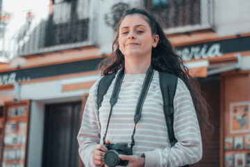 Mujer convencida joven veraneante trotamundos realizando fotos en la ciudad con su cámara para una...