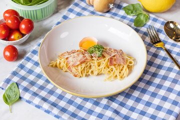 Spaghetti Carbonara on blue gingham fabric