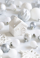 Fototapeta na wymiar White toy house with white and silver Christmas decorations closeup