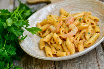  Italian home made   pennette pasta with smoked salmon , creamy sauce and fresh dill on wooden background