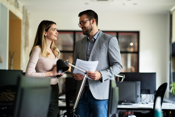Obraz premium Colleagues in office. Businesswoman and businessman discussing work in office..