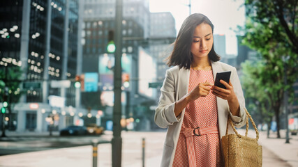 Portrait of an Attractive Japanese Female Wearing Smart Casual Clothes and Using Smartphone on the...