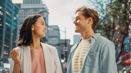 Portrait of a Young Stylish Multiethnic Couple Standing on a Street in a Big City. Attractive Japanese Female and Handsome Caucasian Male Looking Around. Diverse Friends Enjoying Travelling Together.