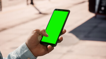 Close Up of a Young Man Using Smartphone with Green Screen Chroma Key Mock Up Display in Vertical...