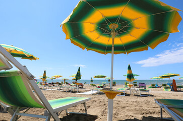 Deckchair on the beach under the umbrella during a hot summer day