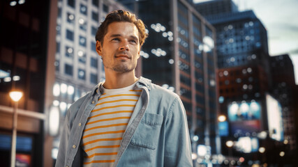 Portrait of a Happy Handsome Young Man in Casual Clothes Standing on the Street at Sunset. Stylish...