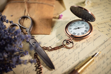 Fototapeta na wymiar Vintage writing utensils on a wooden table, old watch, papers, letters, envelopes and scissors