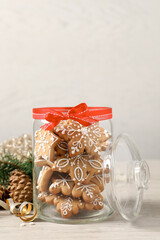 Tasty Christmas cookies in glass jar and festive decor on beige wooden table