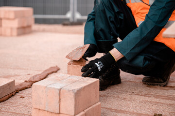 Bricklayer troweling mortar on brick