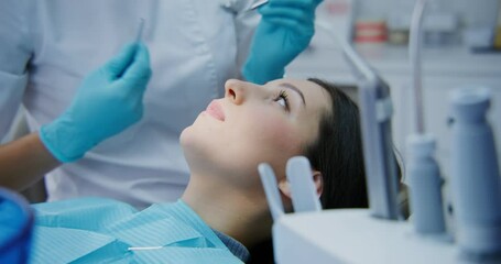 The dentist takes a medical instrument and examination oral cavity of a women