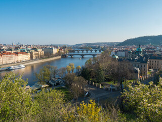 Fototapeta na wymiar Scenic aerial view of Prague Old Town architecture and Charles Bridge over Vltava river seen from Letna hill park, spring sunny day, blue sky, Czech Republic