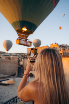 Woman taking picture of hot air balloons