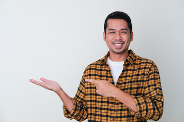 Fototapeta premium Adult Asian man pointing to his hand hand palm with smiling face