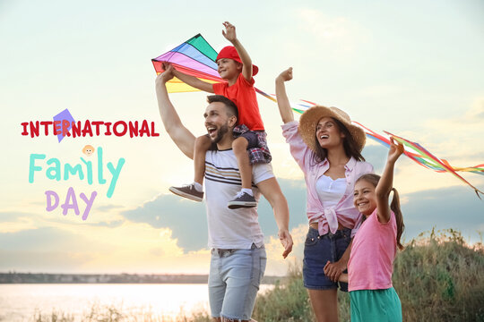 Happy parents and their children playing with kites outdoors. Happy Family Day