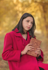 A girl with a book in the autumn forest