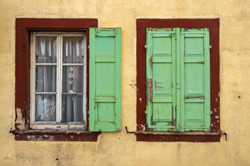 Fototapeta na wymiar View of two windows in a house in need of renovation 