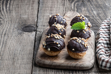 Round chocolate cookies filled with toffee cream on wooden table