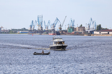 Larger boat cruising near smaller fisherman boat.