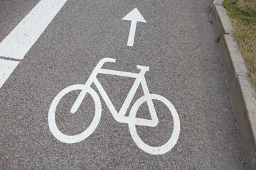 Close-up photo of bicycle road with bicycle sign on asphalt.