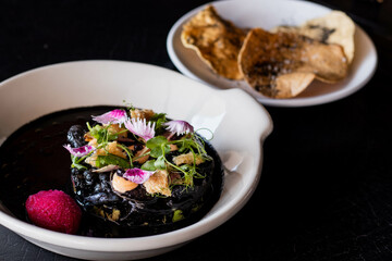 Calamares en su tinta con arúgula y flores 